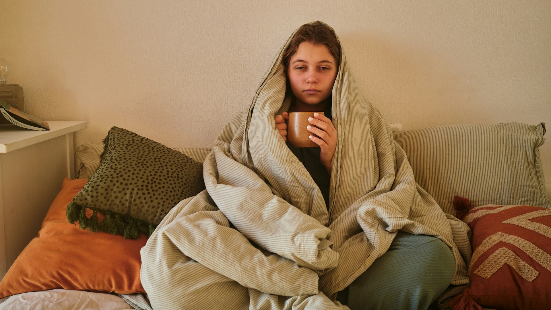 woman at home wrapped in blanket